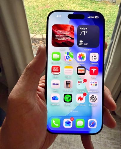 Cliente sosteniendo un iPhone 17 PRO con la pantalla de inicio brillante encendida.