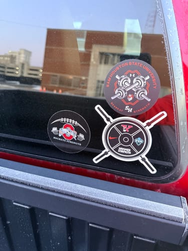 Customer's custom stickers for university strength programs, including Sam Houston, on a truck's rear window.