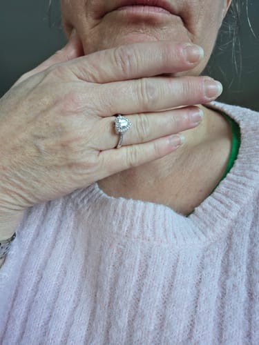 Reviewer's hand held to their neck, displaying the heart-shaped Forever In My Heart Urn Ring.