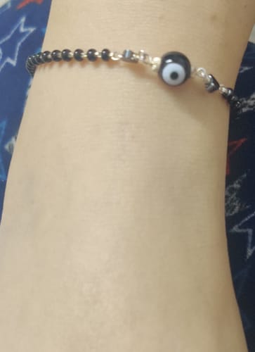 Close-up of a customer's ankle wearing the Silver Black Evil Eye Anklet, showing the black beaded chain and central charm.