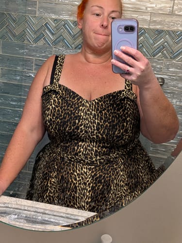Reviewer taking a mirror selfie wearing the leopard print Maneater Swing Dress, showing the fit of the bodice.