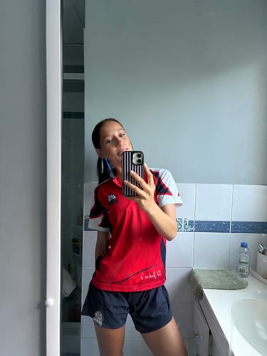 Reviewer taking a mirror selfie, showing the striped Mocha Mirage iPhone Case on their phone.