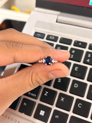 Reviewer holding the Silver Blue Admiring Ring, showing its elegant blue stone and silver band.