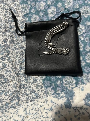 La Pulsera Miami Cuban de un cliente sobre su estuche de transporte negro con cordón.