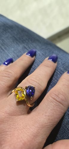 Reviewer's hand showing the Navae Birthstone Ring with a yellow radiant-cut and a blue pear-cut stone.