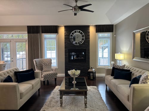 Customer's custom wall art, a large mirrored clock, shown as a focal point in their elegant living room.