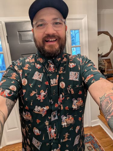 Reviewer wearing the dark green 'The Muppet Christmas Carol' patterned short sleeve shirt.