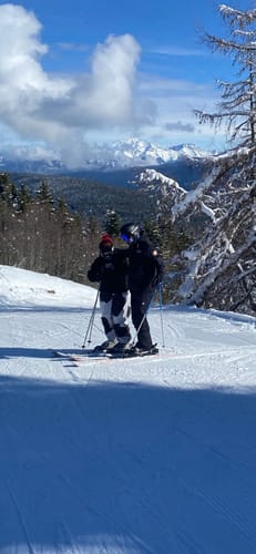 Customer skiing on a snowy mountain slope in the baggy, cow print snow pants.