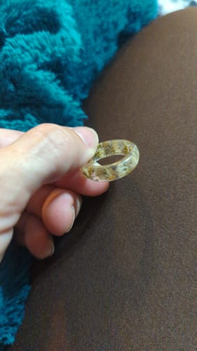 A customer holds their clear resin Yellow Flower Ring, showing the yellow petals suspended inside.