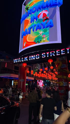 Rezensent zeigt ein mit der NUVINT-Digitalkamera aufgenommenes Nachtfoto der belebten Walking Street in Pattaya.