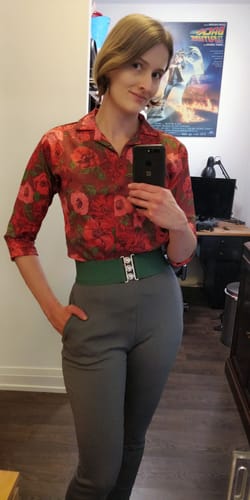 Reviewer shows the fit of the floral 1950s Vintage Style Button Up Blouse, tucked into pants.