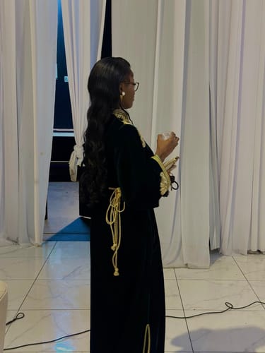 Reviewer from behind wearing the Samar Dark Green kaftan, showing the detailed gold tie at the waist.