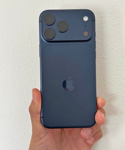 Cliente mostrando la parte trasera de un IPHONE 17 PRO MAX azul en la mano.