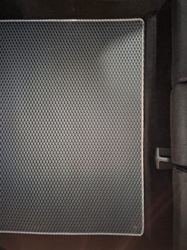 Zbliżenie na szary dywanik do bagażnika od klienta, pokazujący jego diamentową teksturę i dopasowanie w rogu.