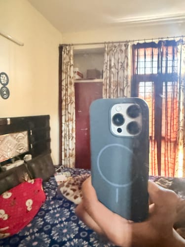 Customer holding the grey Anti Dust Magsafe Silicone Case on an iPhone in a mirror photo.