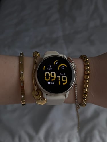 Customer's wrist stacked with several gold bracelets from the jewelry bundle, worn alongside a watch.