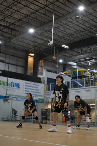 Reviewer and teammates wearing their Personalized MSBY Black Jackals T-shirts during a volleyball game.