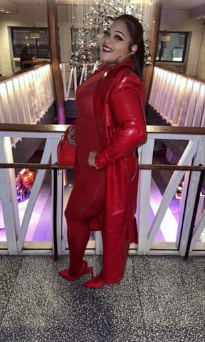 Reviewer showing off the red Naked Closed Toe Legging styled with a matching red coat and heels.