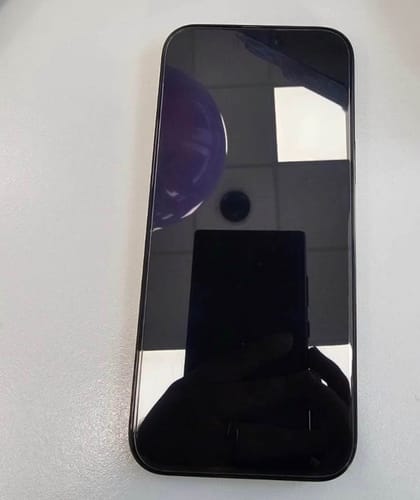 Cliente mostrando la parte frontal del IPHONE 16 PRO MAX con la pantalla negra apagada sobre una mesa.