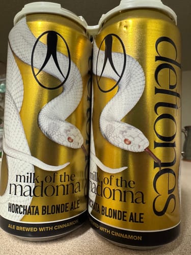 Customer's four-pack of Belching Beaver Deftones Milk Of The Madonna ale in shiny gold cans with white snake art.