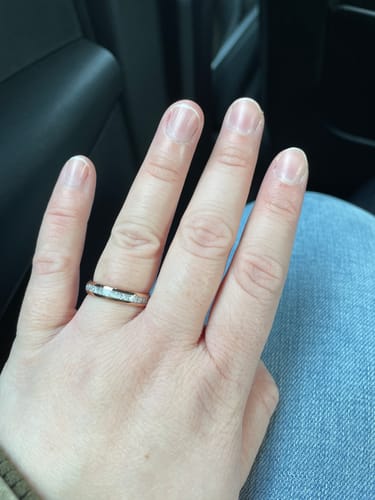 Close-up of a customer's hand wearing the Rosmir ring, showing the rose gold band and silver inlay.