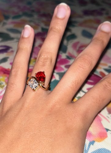 Customer wearing the gold Navae Birthstone Ring with a red pear-cut stone and a clear radiant-cut stone.