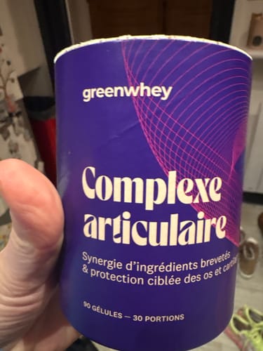 Un client tient le pot violet de Complexe Articulaire dans sa main.