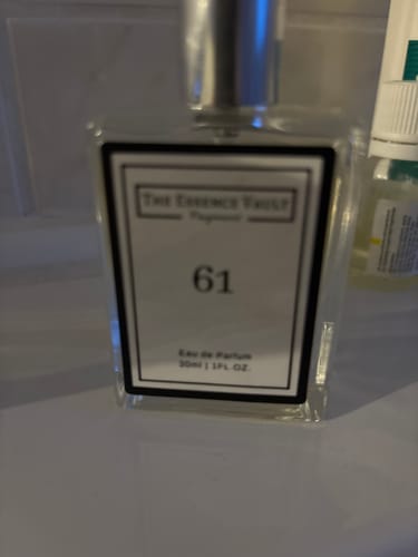 Close-up of a reviewer's No. 61 perfume bottle, showing the white label and silver cap.