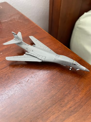 Customer's grey GEMINIMACS USAF B1B model aircraft sitting on a wooden desk.