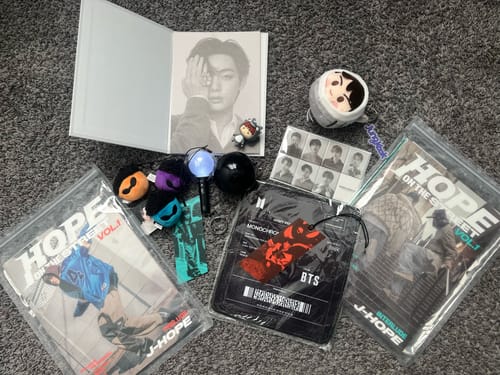 Reviewer shows their K-POP RANDOM BOX haul, including J-Hope albums, BTS merch, and a lightstick keychain.
