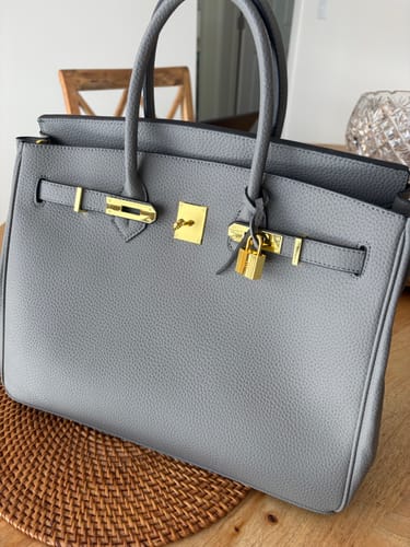 Customer's grey, textured Warkin Bag size 35 with gold hardware resting on a wooden table.