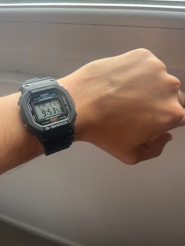 Cliente mostrando en su muñeca el reloj negro Casio G-Shock Vintage.