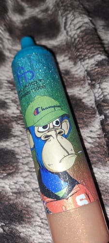 Kunde zeigt eine Nahaufnahme des glitzernden RANDM TORNADO 15000 mit einem bunten Cartoon-Affen-Design.