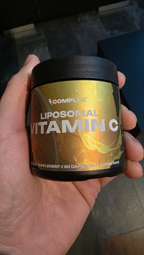 Customer holding the black and gold bottle of Complex Liposomal Vitamin C.