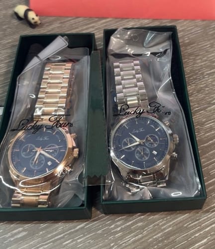 Customer's two Lucky Fours® Ronin watches, one rose gold and one silver, resting in their open boxes.