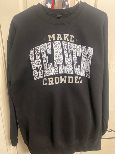 Reviewer's black Make Heaven Crowded Sweatshirt hanging indoors, showing the leopard-print text.