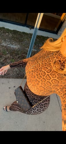 Reviewer in a high-angle shot wearing the Naked Print Bodysuit and matching leggings.