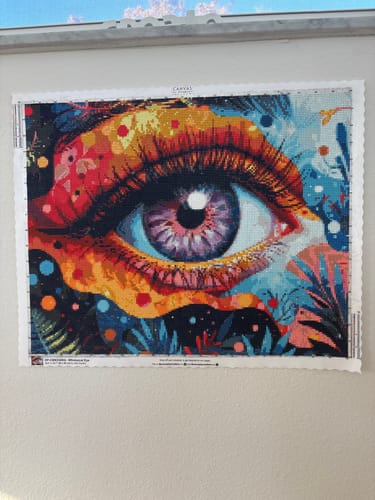 Reviewer's completed Whimsical Eye diamond painting of a colorful, abstract eye shown hanging on a wall.