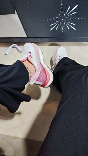 Customer's overhead view of the white and pink Bacca Bucci HYPERSOFT SERIES shoe being worn with black pants.