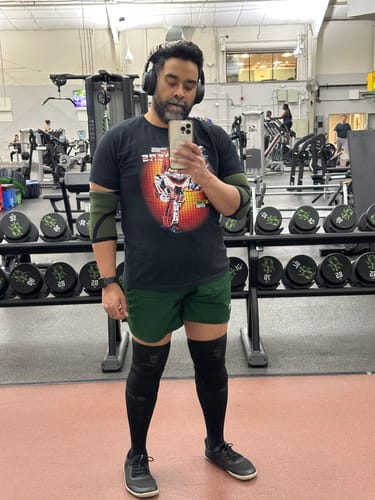 Reviewer taking a mirror selfie at the gym wearing the black Box Art Jetfire Transformers T-Shirt.