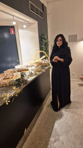 Reviewer standing indoors wearing the long, black Kaftan Liam Black.