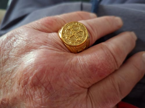 Reviewer wearing the gold-colored St. Benedict the Protector Ring, showing its clear and detailed design on their finger.