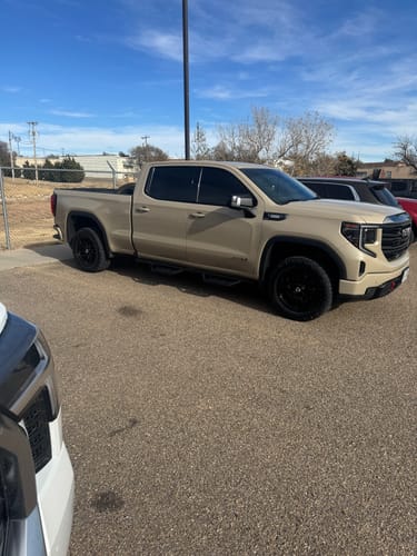 Customer's tan GMC Sierra truck, a vehicle compatible with the GM Duramax LM2 Delete Tune, parked in a lot.