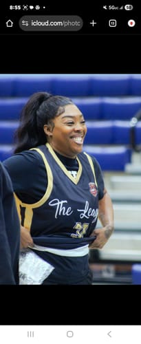 A reviewer smiling while wearing the custom black and yellow basketball jersey in a gym.