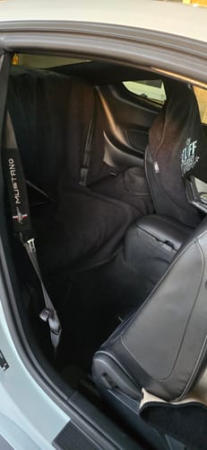 Customer's black waterproof seat cover fitted across the backseat of a Ford Mustang, protecting the interior.