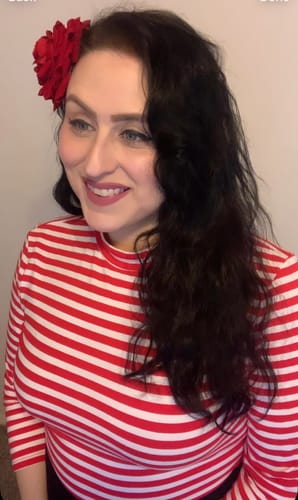 Reviewer smiling while wearing the fitted Bad Girl 3/4 Sleeve Top in red and white stripes.