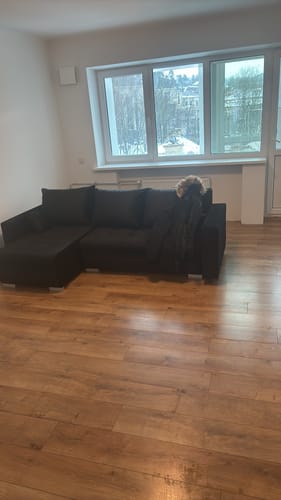 Kliento tamsus minkštas kampas LOKO, pastatytas kambaryje su medinėmis grindimis.
