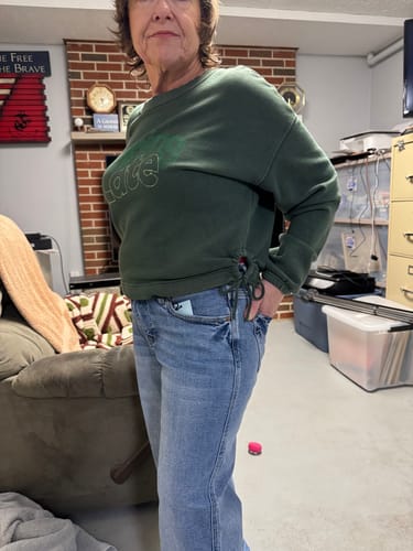 Reviewer showing the side profile and fit of the light-wash My Main Focus Petite Straight Leg jeans in a living room.