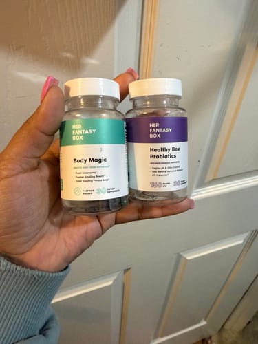Customer holding the Body Magic and Healthy Box Probiotics supplement bottles from the Ultimate Glow-Up Kit.
