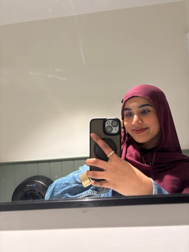 Reviewer taking a mirror selfie wearing the burgundy Sumac Premium Modal hijab indoors.